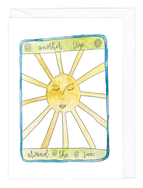 Greeting card with a sun illustration and text 'another trip around the sun' on a white background