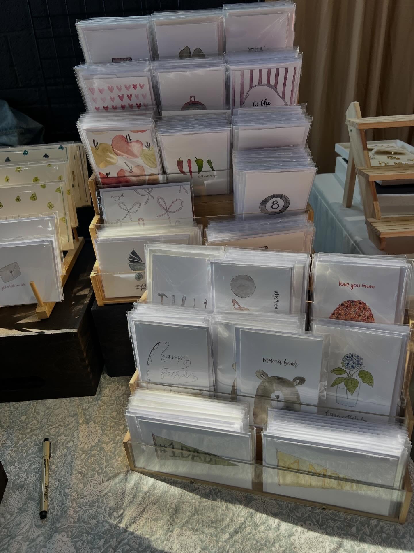 Display of various greeting cards in a holder on a table, at a market.